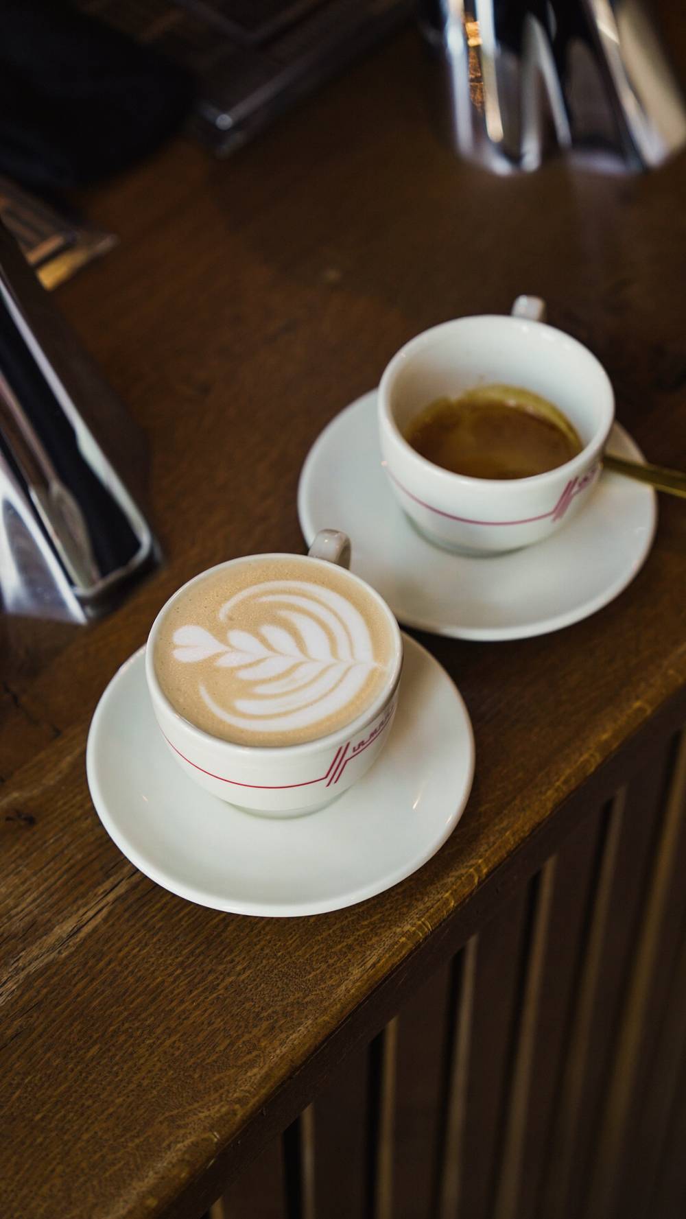 Cappuccino cu latte art și espresso pe barul cafenelei